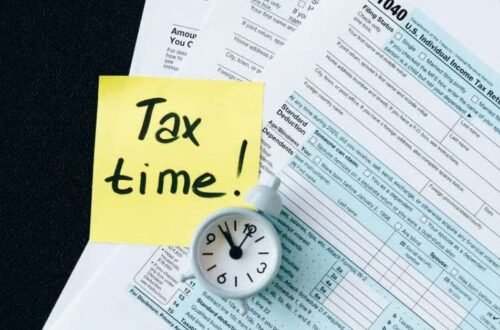 Small business owner reviewing LLC and S Corp structure options with a laptop and tax documents at a desk