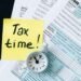 Small business owner reviewing LLC and S Corp structure options with a laptop and tax documents at a desk
